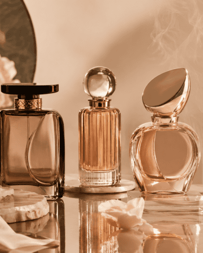 Elegant collection of luxury perfume bottles with warm lighting and soft background.